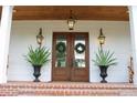 Double front doors with lanterns and planters on a brick porch at 2293 Eldorado Ct, St Cloud, FL 34771