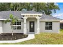 Front entry of a new home featuring a modern door and stone accents at 1055 W French Ave, Orange City, FL 32763