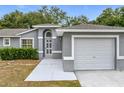 Gray house with white accents, arched entryway, and attached garage at 14837 Siplin Rd, Winter Garden, FL 34787