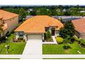 One-story house with orange tile roof, driveway and green lawn at 4027 Oakrise Loop, Davenport, FL 33837