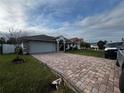 House exterior showcasing a gray garage door and a brick paved driveway at 761 Americana Ct, Kissimmee, FL 34758