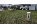 Landscaped front yard with lush grass and a mature palm tree at 761 Americana Ct, Kissimmee, FL 34758