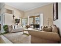 Cozy living room with access to backyard, featuring comfortable seating and a large window at 1556 Auburn Oaks Ct, Auburndale, FL 33823
