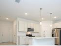 Modern kitchen with white cabinets, stainless steel appliances, and an island at 15398 Sw 22Nd Court Rd, Ocala, FL 34473