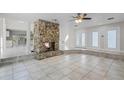 Open living area with a stone fireplace and tiled floors at 203 Red Bud Ln, Longwood, FL 32779