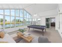 Sunroom with a pool table and large windows overlooking the water at 3149 Bear Path, Kissimmee, FL 34746