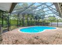 An enclosed kidney-shaped swimming pool with brick decking at 402 Satsuma Dr, Sanford, FL 32771