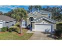 Two-story house with gray siding, white garage door, and palm tree in front at 8048 King Palm Cir, Kissimmee, FL 34747