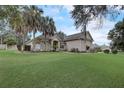One-story house with large green lawn, palm trees, and a red front door at 4320 Se 106Th St, Belleview, FL 34420