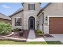 Front entry of two-story house with stone veneer and screen door at 6701 Sw 94Th Cir, Ocala, FL 34481