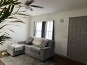 Living room with grey sectional sofa, ottoman, and wood-look floors at 4852 Sw 144Th St, Ocala, FL 34473