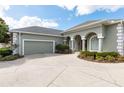 Green house exterior with a large driveway and garage at 3051 Sw 41St Pl, Ocala, FL 34474