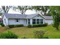 Single story home with gray siding and sunroom addition at 8239 Sw 108Th St, Ocala, FL 34481