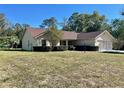 Single-story house with a large front yard and mature trees at 10787 Sw 53Rd Cir, Ocala, FL 34476