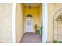 Front entry with a white door, terracotta tile flooring and potted plants at 567 Silver Course Run, Ocala, FL 34472