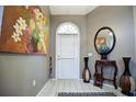 Bright entryway with tile floor, large artwork, and a decorative table at 567 Silver Course Run, Ocala, FL 34472