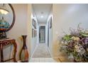 Hallway with carpeted floor, framed pictures on the wall, and a large plant at 567 Silver Course Run, Ocala, FL 34472
