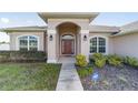 House exterior featuring a walkway to the front door, landscaping, and a neutral color palette at 3235 Se 43Rd Ave, Ocala, FL 34480