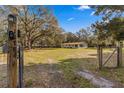 Landscaped yard with gated entry and mature trees at 11782 Sw 140Th St, Dunnellon, FL 34432