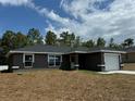 Newly built home with grey exterior, landscaping and driveway at 235 Locust Ln, Ocala, FL 34472