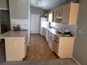Long galley kitchen with light wood cabinets and flooring at 7946 Juniper Rd, Ocala, FL 34480