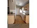 Long galley kitchen with light wood cabinets and flooring at 7946 Juniper Rd, Ocala, FL 34480