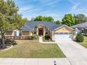 Single-Gathering home with a red door and two-car garage at 4725 Sw 62Nd St, Ocala, FL 34474