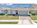 One-story home with gray siding, two-car garage, and landscaped yard at 5662 Nw 40Th Pl, Ocala, FL 34482