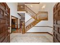Grand entryway with tiled floor, wooden staircase, and double doors at 7086 Se 12Th Cir, Ocala, FL 34480