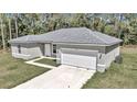 Newly built single-story house with gray siding, white garage door, and a neat lawn at 6839 Sw 149Th Lane Rd, Ocala, FL 34473