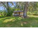 Small house exterior with large oak tree in yard at 11531 Se 60Th Ave, Belleview, FL 34420