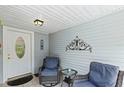 Relaxing front porch with wicker chairs and small table at 612 Fannich Ct, Leesburg, FL 34788