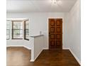 Bright entryway with wood flooring, a half-wall, and a wood door at 8975 Sw 202Nd Avenue Rd, Dunnellon, FL 34431