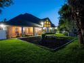 Spacious backyard with a fire pit and screened porch at night at 1719 Sw 27Th Pl, Ocala, FL 34471