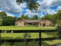 Brick home with a large grassy yard and black fence at 5424 Sw 31St St, Ocala, FL 34474