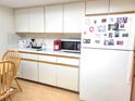 Kitchen with white cabinets, a microwave, and a refrigerator at 10765 Sw 62Nd Ter, Ocala, FL 34476