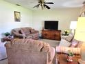 Living room with two brown couches, a TV, and a wooden cabinet at 10765 Sw 62Nd Ter, Ocala, FL 34476