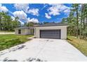 New construction home exterior, featuring a gray garage door and white siding at 13359 Sw 80Th St, Dunnellon, FL 34432