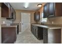Dark brown cabinets and granite countertops in a galley style kitchen at 83 Malauka Radl, Ocklawaha, FL 32179