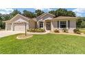 Two-car garage, single-story home exterior at 10020 Sw 202Nd Cir, Dunnellon, FL 34431