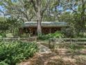 Rustic home exterior with a wraparound porch and lush landscaping at 4344 Cr 542H, Bushnell, FL 33513