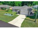Single-story home with a large driveway and landscaped front yard at 13027 Ne 7Th Loop, Silver Springs, FL 34488