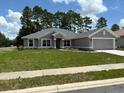 Single-story home with gray exterior and a two-car garage at 7027 Sw 179Th Court Rd, Dunnellon, FL 34432