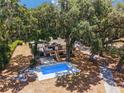 Aerial view of a house with a pool, surrounded by lush trees at 14260 Ne 40Th Ct, Anthony, FL 32617