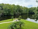 Scenic waterfront view with lush greenery and a fire pit area at 56633 Otter Rd, Astor, FL 32102