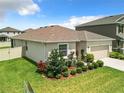 Tan house with a two-car garage and landscaped backyard at 8857 Sw 50Th Ter, Ocala, FL 34476