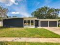 Mid-century modern home with dark gray and white exterior, two-car garage, and manicured lawn at 4612 Bradley Ave, Orlando, FL 32839