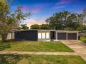 Mid-century modern home with dark gray and white exterior, two-car garage, and manicured lawn at 4612 Bradley Ave, Orlando, FL 32839