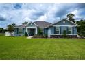 Single-story home with blue siding, stone accents, and a lush lawn at 3900 Se 23Rd St, Ocala, FL 34471