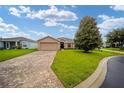 Single-story house featuring a paved driveway and lush green lawn at 16292 Sw 13Th Ter, Ocala, FL 34473